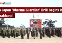 India-Japan ‘Dharma Guardian’ Drill Begins in Uttarakhand A group of Indian and Japanese soldiers standing in formation at an outdoor military grounds for the 'Dharma Guardian' joint exercise in Uttarakhand. A large banner and the national flags of India and Japan are visible in the background, with the Maps of India logo in the top left corner.