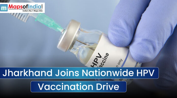 Jharkhand Joins Nationwide HPV Vaccination Drive An image featuring a close-up of a gloved hand holding an HPV vaccine vial being accessed by a syringe, with a text overlay that reads "Jharkhand Joins Nationwide HPV Vaccination Drive" and a Maps of India logo.