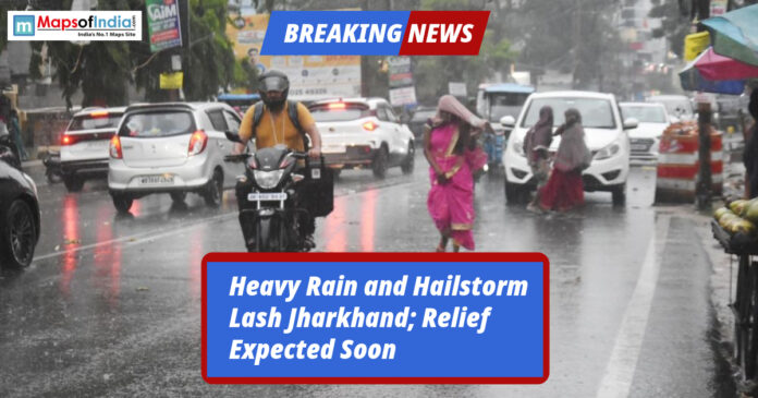 People and vehicles struggle on a rain-soaked road during heavy rainfall and hailstorm in Jharkhand.