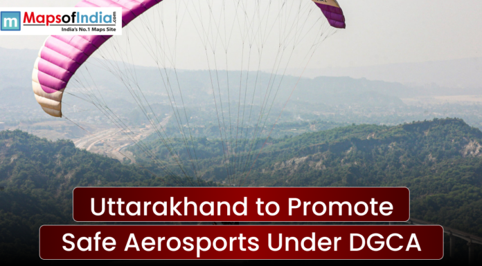 Uttarakhand to Promote Safe Aerosports Under DGCA A wide scenic shot of a person paragliding over a lush green mountainous valley under a clear sky. A text banner reads "Uttarakhand to Promote Safe Aerosports Under DGCA" with the Maps of India logo in the top left.