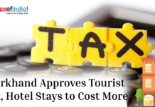 Jharkhand Approves Tourist Tax, Hotel Stays to Cost More Illustration showing “TAX” written on puzzle pieces over a calculator with the headline about Jharkhand approving a tourist tax that may increase hotel stay costs.