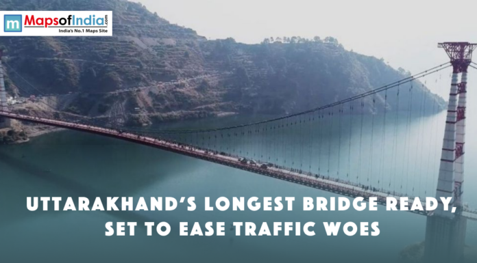 Uttarakhand’s Longest Bridge Ready, Set to Ease Traffic Woes A long suspension bridge over a river in Uttarakhand, surrounded by hills, with text announcing it as the state’s longest bridge ready to ease traffic.
