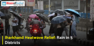 Jharkhand Heatwave Relief: Rain in 5 Districts People walking with umbrellas on a rainy street during weather relief from the Jharkhand heatwave.