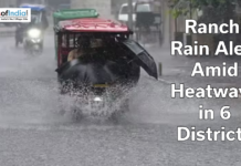 Ranchi Rain Alert Amid Heatwave in 6 Districts Auto-rickshaw driving through heavy rain on a flooded road in Ranchi with text overlay about rain alert amid heatwave in six districts.
