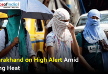 Uttarakhand on High Alert Amid Rising Heat Three people with faces covered walking outdoors under an umbrella during a heatwave.