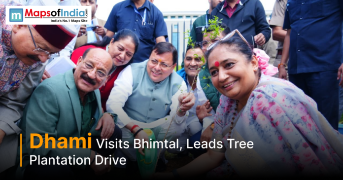 Uttarakhand Chief Minister Pushkar Singh Dhami participates in a tree plantation drive during his visit to Bhimtal, surrounded by officials and local residents.