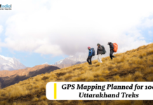 GPS Mapping Planned for 100 Uttarakhand Treks Trekkers hiking across a mountain slope in Uttarakhand with snow-capped peaks in the background, highlighting GPS mapping plans for 100 trekking routes.
