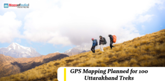 GPS Mapping Planned for 100 Uttarakhand Treks Trekkers hiking across a mountain slope in Uttarakhand with snow-capped peaks in the background, highlighting GPS mapping plans for 100 trekking routes.